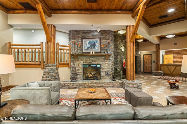 tiled living room with beamed ceiling, a stone fireplace, and wood ceiling