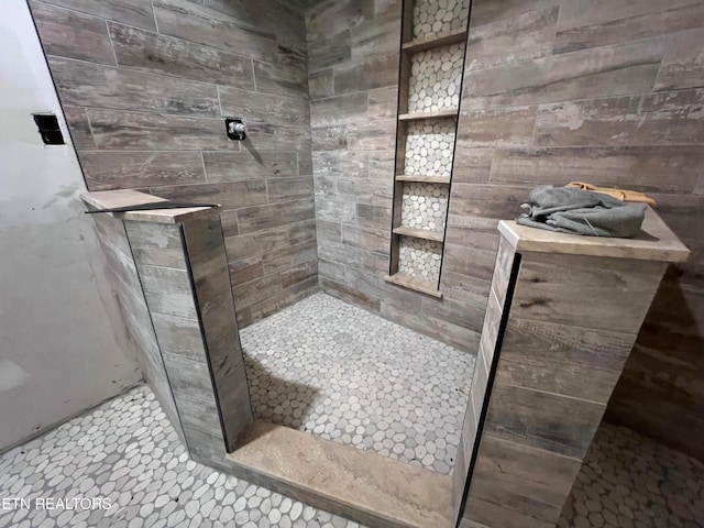 bathroom featuring tiled shower and tile flooring