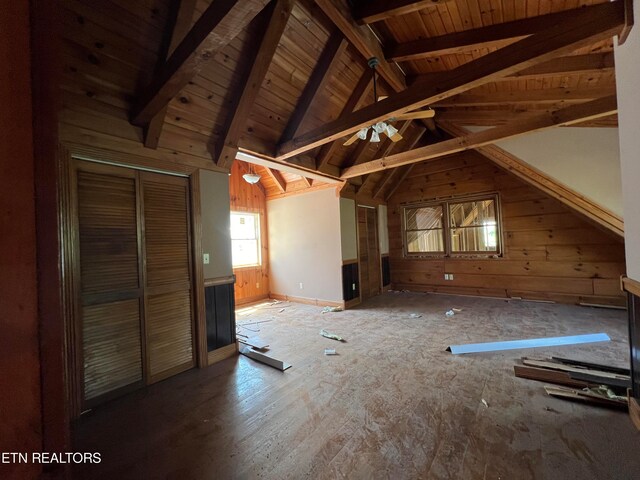 interior space with wood-type flooring, wooden ceiling, lofted ceiling with beams, and wooden walls