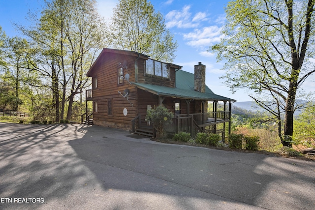 log home featuring covered porch