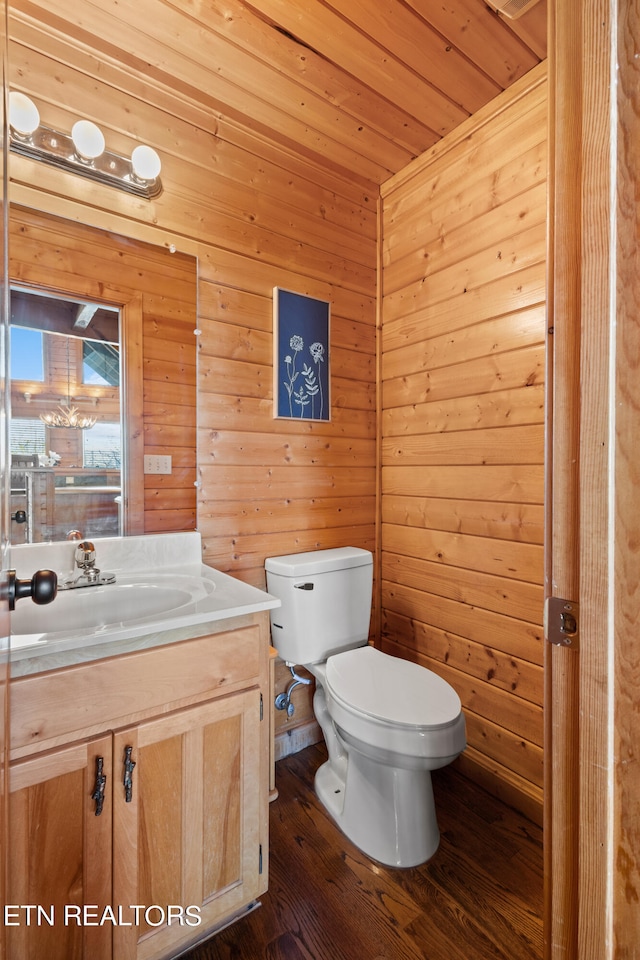 bathroom featuring hardwood / wood-style floors, wooden walls, toilet, wooden ceiling, and vanity