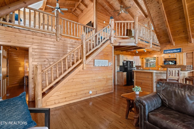 living room with hardwood / wood-style floors, wooden ceiling, wooden walls, and high vaulted ceiling