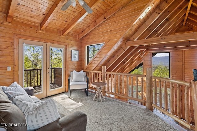 living room with wooden ceiling, wood walls, ceiling fan, and vaulted ceiling with beams