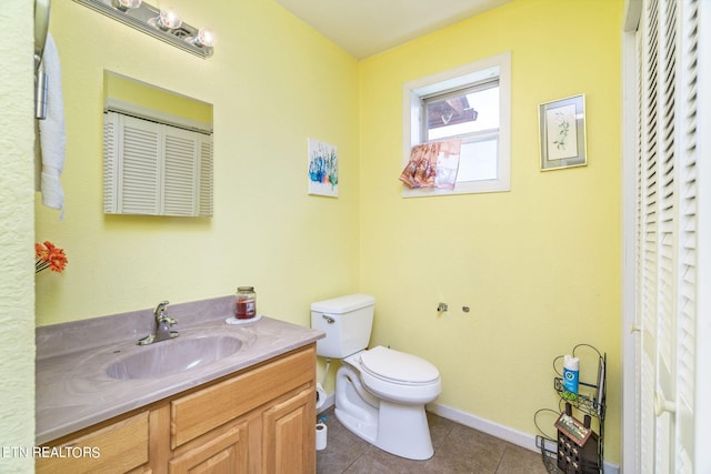 bathroom with toilet, tile flooring, and vanity