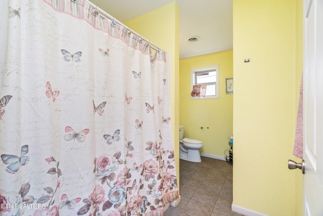 bathroom with toilet and tile floors