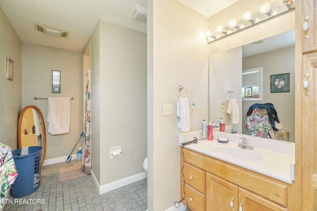 bathroom with vanity, tile floors, and toilet