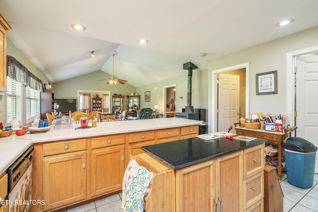 kitchen featuring ceiling fan, white dishwasher, lofted ceiling, a wood stove, and light tile floors