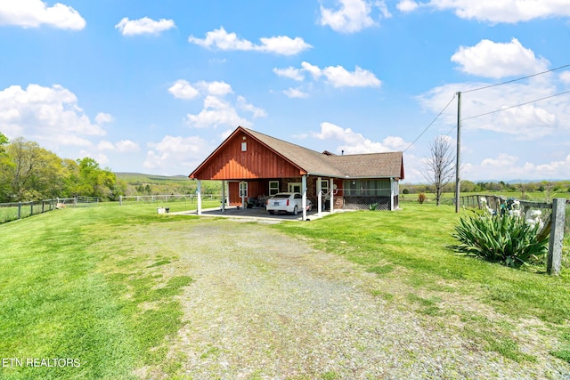 exterior space with a carport and a lawn