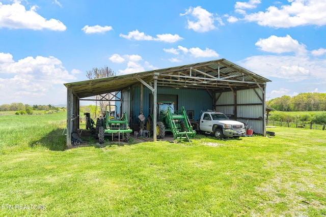 rear view of house with a rural view and a lawn