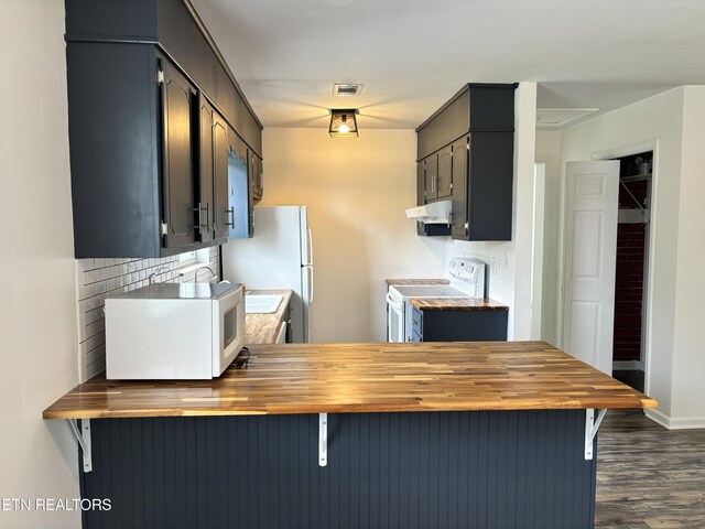 kitchen featuring wood counters, dark hardwood / wood-style floors, white appliances, and extractor fan