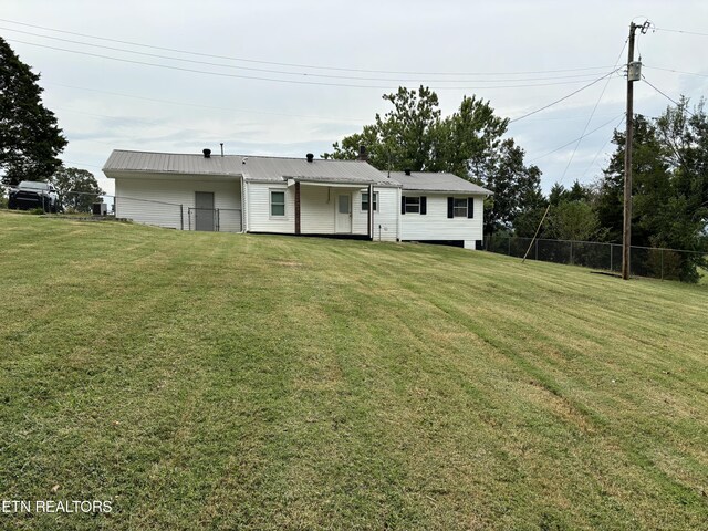 rear view of property featuring a lawn