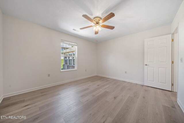 spare room with ceiling fan and light wood-type flooring