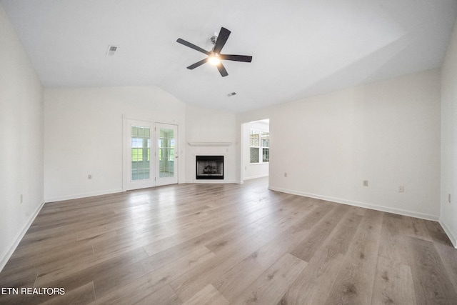 unfurnished living room with lofted ceiling, ceiling fan, and light wood-type flooring