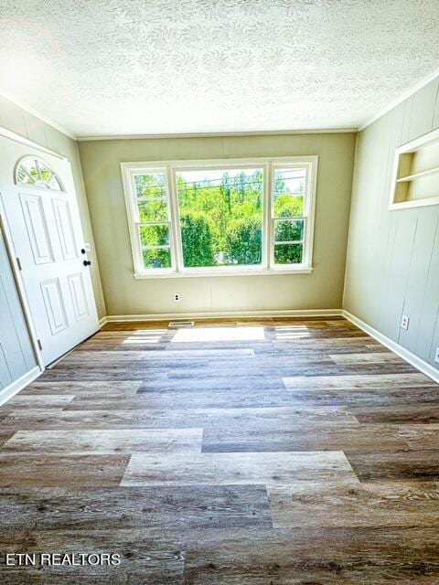 unfurnished room with wood-type flooring and a textured ceiling