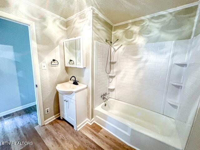 bathroom with shower / washtub combination, wood-type flooring, vanity, ornamental molding, and a textured ceiling