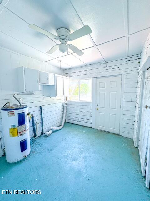 interior space with concrete floors, water heater, and ceiling fan