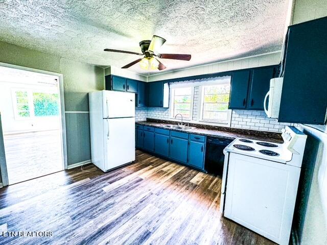 kitchen featuring white appliances, hardwood / wood-style floors, blue cabinetry, tasteful backsplash, and ceiling fan