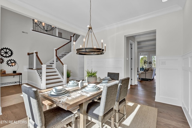 dining area with crown molding, dark hardwood / wood-style floors, and a notable chandelier