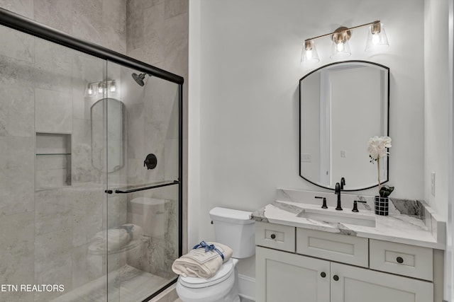 bathroom featuring an enclosed shower, vanity, and toilet