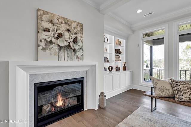 interior space featuring a fireplace, ornamental molding, and dark hardwood / wood-style flooring