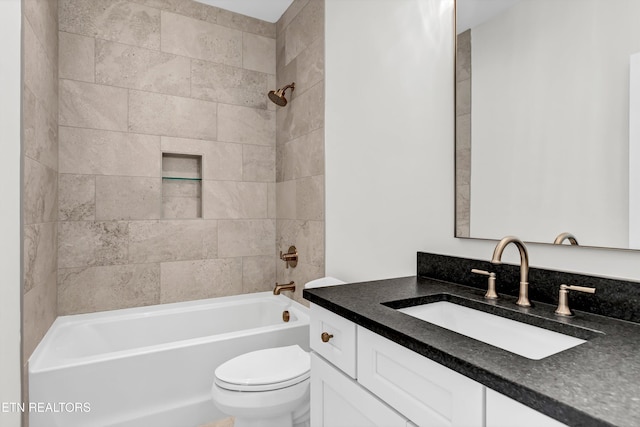 full bathroom featuring toilet, tiled shower / bath, and vanity