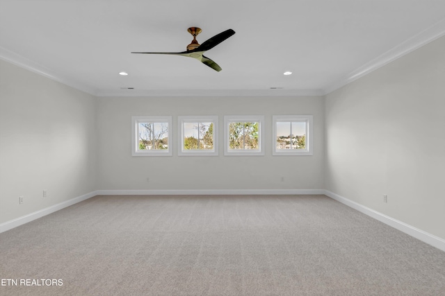 carpeted spare room featuring crown molding, ceiling fan, and a wealth of natural light