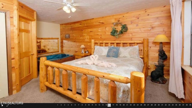 bedroom with a textured ceiling, wood walls, ceiling fan, and carpet flooring