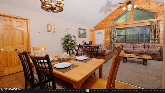 carpeted dining space featuring ceiling fan with notable chandelier and lofted ceiling