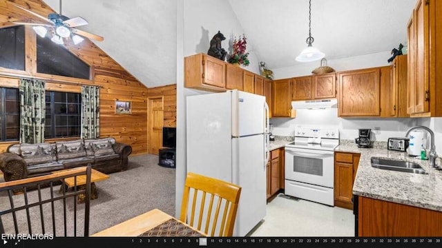 kitchen with wood walls, white appliances, ceiling fan, light carpet, and sink