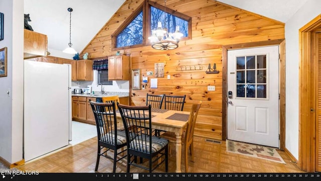 dining space featuring vaulted ceiling, sink, and light parquet flooring