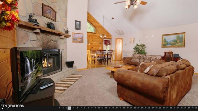 living room with wooden walls, carpet, vaulted ceiling, a stone fireplace, and ceiling fan