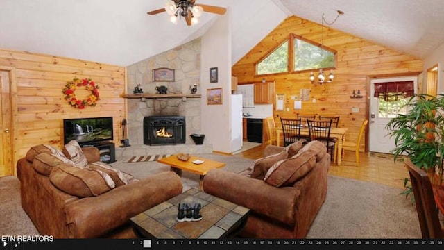 living room with high vaulted ceiling, ceiling fan, a stone fireplace, and carpet floors