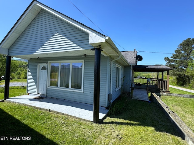 view of side of home featuring a yard and a deck