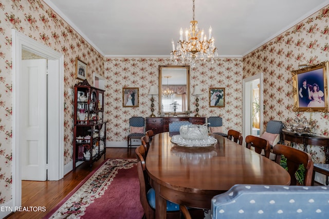 dining space with hardwood / wood-style floors, crown molding, and a chandelier