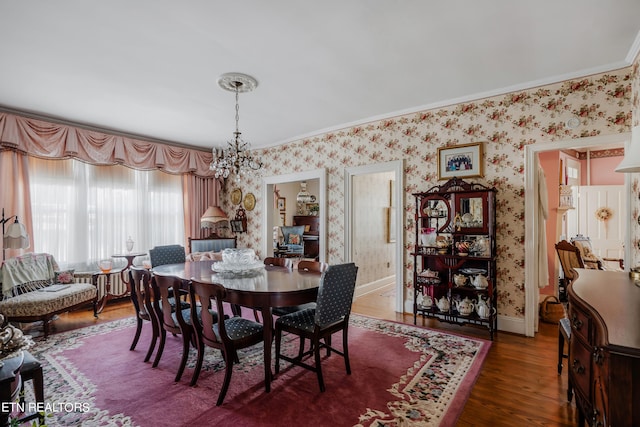 dining space featuring dark hardwood / wood-style floors, a notable chandelier, and crown molding