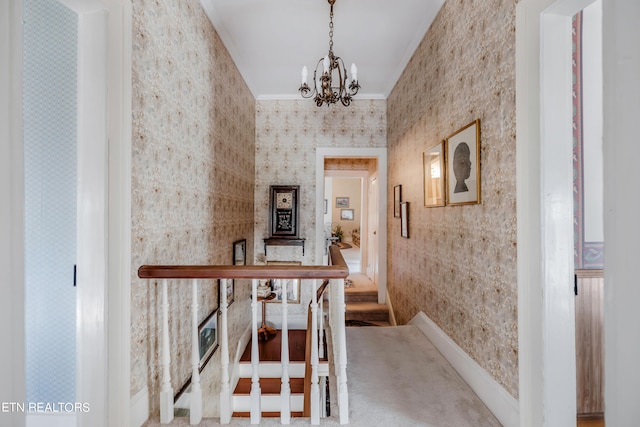 corridor with ornamental molding, carpet floors, and a notable chandelier