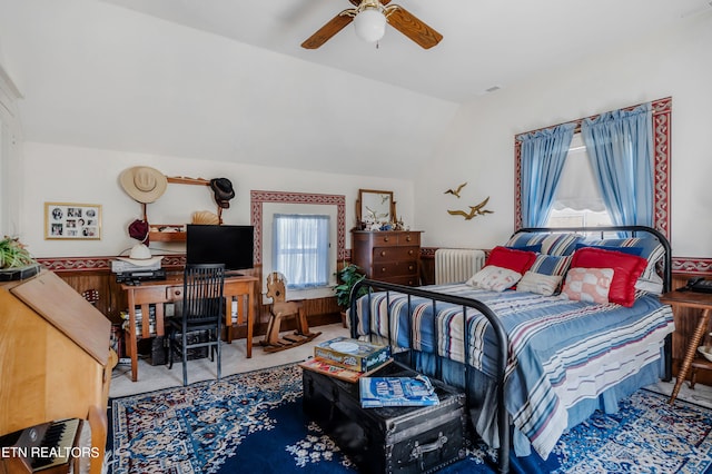 carpeted bedroom with ceiling fan, vaulted ceiling, and radiator heating unit