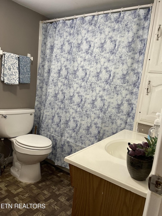 bathroom featuring vanity, toilet, and parquet floors