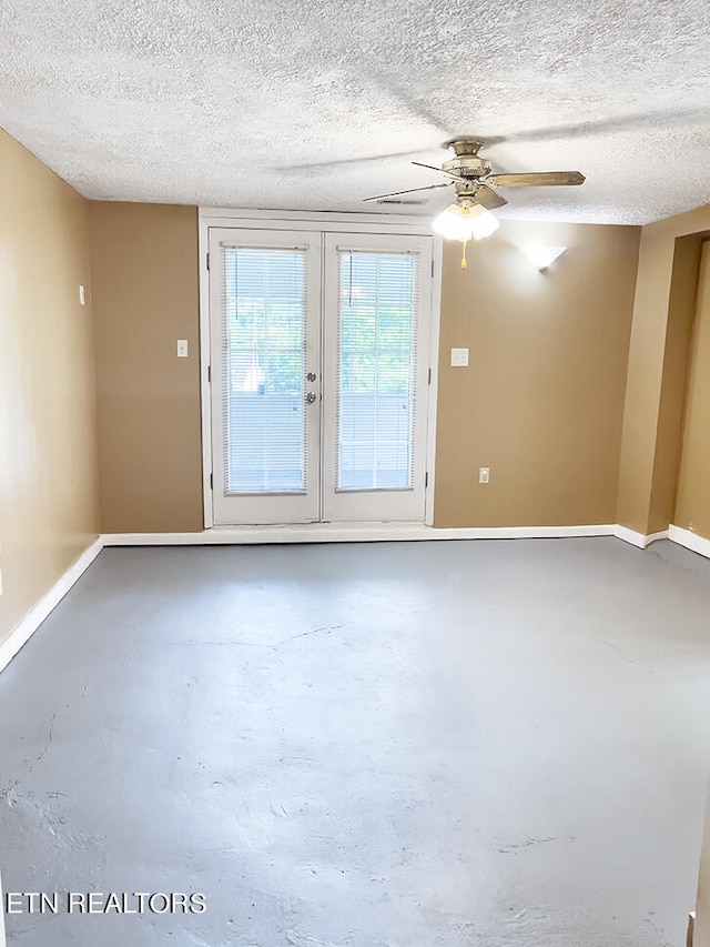 empty room featuring ceiling fan, french doors, concrete floors, and a textured ceiling