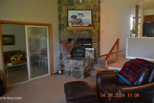 living room with a stone fireplace and carpet