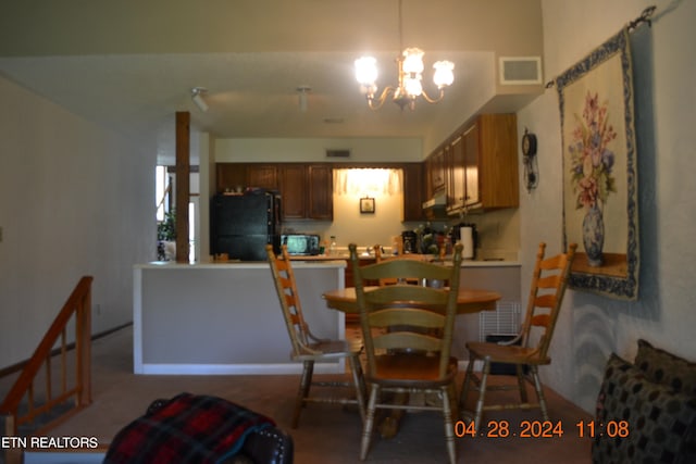 dining space featuring carpet and a chandelier