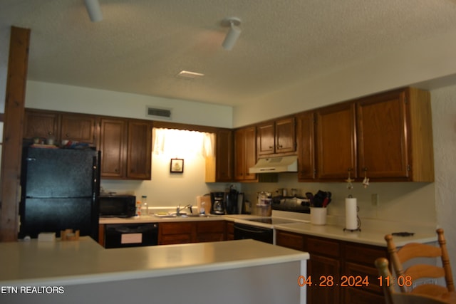 kitchen featuring sink, black appliances, and a textured ceiling