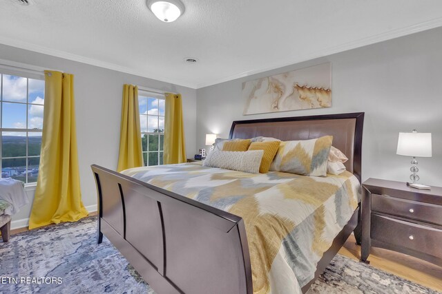 bedroom featuring hardwood / wood-style flooring and crown molding