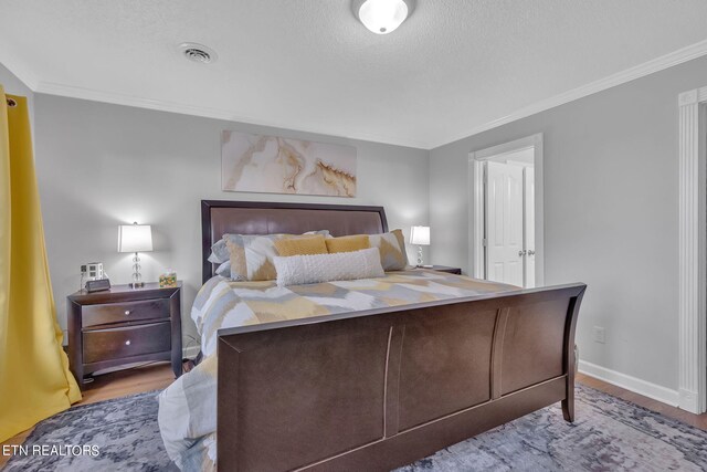 bedroom with wood-type flooring and ornamental molding