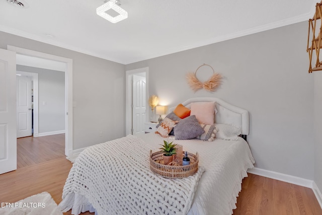 bedroom featuring wood-type flooring and crown molding