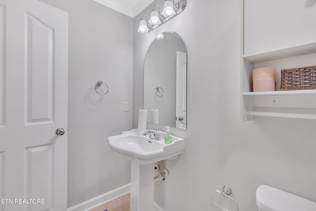 bathroom with tile flooring, toilet, and ornamental molding