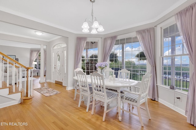 dining area featuring a notable chandelier, crown molding, light wood-type flooring, and a wealth of natural light