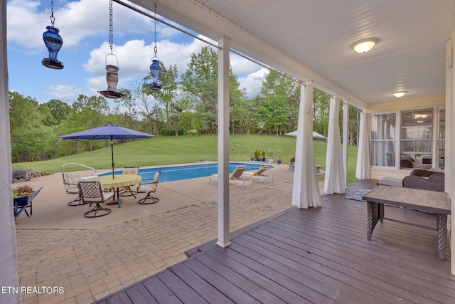 exterior space featuring a patio area, a deck, and a lawn