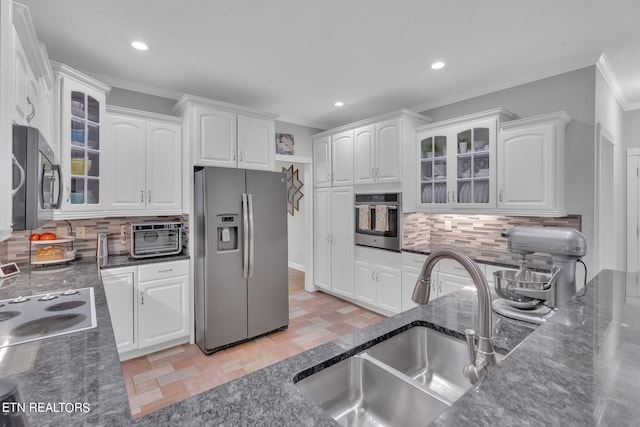 kitchen featuring white cabinets, appliances with stainless steel finishes, backsplash, and light tile floors