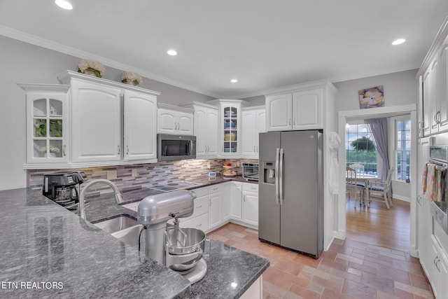 kitchen featuring appliances with stainless steel finishes, tasteful backsplash, white cabinets, and ornamental molding